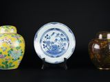 trois vases et un bol sont posés sur une surface noire