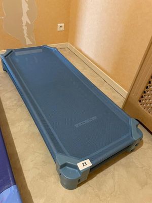 a blue cot that is on the floor in a room