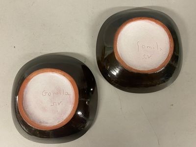 two black and white plates with orange rims on a table