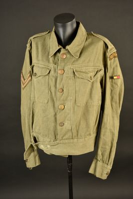 une veste verte posée sur un présentoir à mannequin, sur fond noir