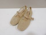 pair of beige shoes on a white surface with a white background