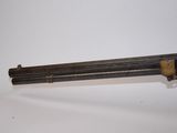 an old gun with a wooden handle on a white surface
