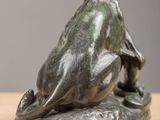 bronze sculpture of a frog on a rock on a table