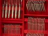 many forks and spoons in a red box