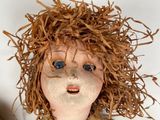 a close up of a doll on a white surface