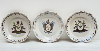 trois assiettes à motifs posées sur une surface blanche