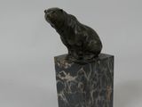 a statue of a bear sitting on top of a marble block