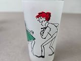 a glass with a drawing of a man and a woman on it
