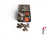 une petite boîte en métal remplie de pièces de monnaie posée sur une surface blanche