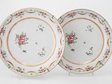deux assiettes à motifs floraux posées sur une surface blanche