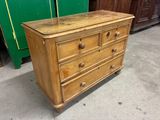 a wooden chest of drawers on the floor