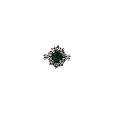 gros plan d'une bague en diamant et émeraude sur fond blanc