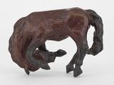 statue d'un cheval tenant un veau dans la bouche, posée sur un socle blanc