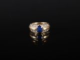 une bague en or sertie d'un saphir et de diamants sur un fond noir