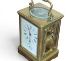 a small brass clock with a glass face on it