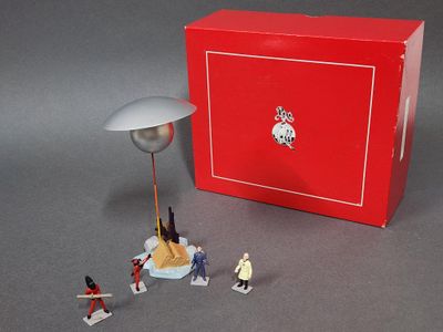 une petite figurine posée sur la table, dans une boîte rouge