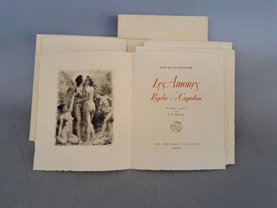 un livre ouvert posé sur une table à côté d'une pile de livres