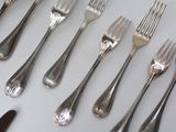 a lot of forks and spoons that are on the table