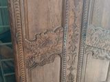 a wooden armoire with carvings on it in a room