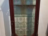 a display case with a glass door in the corner of the room