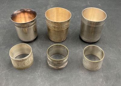 several silver cups and cups are sitting on a table