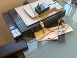 une table en verre sur laquelle se trouvent une imprimante et un téléphone portable