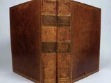 an old book with two books inside of it on a white surface