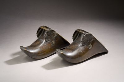 a pair of bronze shoes are sitting on a white surface