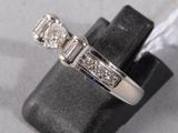 a picture of a three stone diamond ring on a ring stand