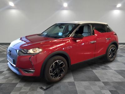Le SUV rouge est garé sur un sol en carrelage à damier.