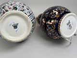 pair of chinese vases with floral designs on them sitting on a table
