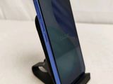 a close up of a cell phone on a stand on a white surface