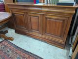 une armoire en bois avec une porte vitrée et un tapis au sol