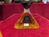 a bottle of perfume sitting on a table with a red table cloth