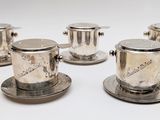 six tasses et soucoupes plaquées argent sur un fond blanc