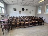 des tables et des chaises dans une pièce où est accrochée une horloge au mur