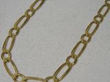 Collier à chaîne plaquée or avec des maillons ovales sur un fond blanc