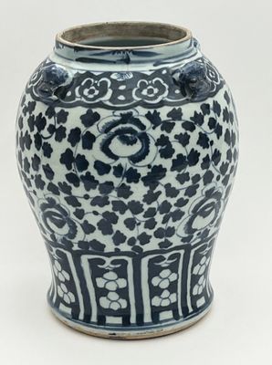 a blue and white vase sitting on a white surface