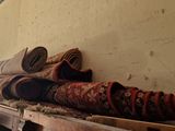 une pile de tapis posée sur une palette dans une pièce