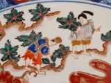 a plate with a painting of a boy and a girl on it