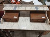 a marble table with two wooden drawers on top of it