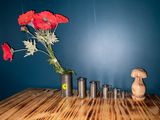 a vase with red flowers in it on a wooden table
