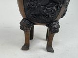 a bronze vase with a dragon on it on a stand