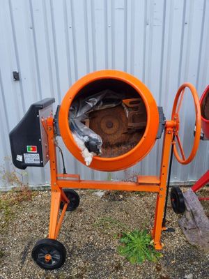 une bétonnière orange posée contre le mur d'un immeuble