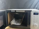 a microwave that is sitting on a table with a bag in it