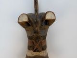 une vieille sculpture en bois représentant une tête de taureau, accrochée au mur