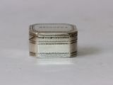 a small silver box sitting on top of a white table