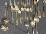 beaucoup de cuillères en argent et de cuillères à soupe sur une table