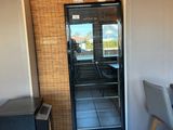 un petit réfrigérateur dans un coin de la pièce, à côté d'une table et de chaises