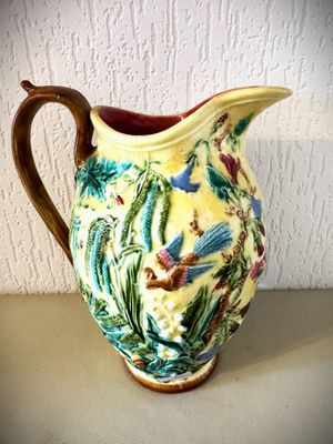 un pichet jaune et vert orné d'un motif représentant un oiseau